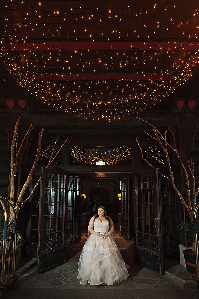 bride is standing at entrance with christmas light surrounding here Chateau Montebello