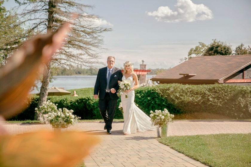 bride is walking with dad down the isle, river background chateau montebello