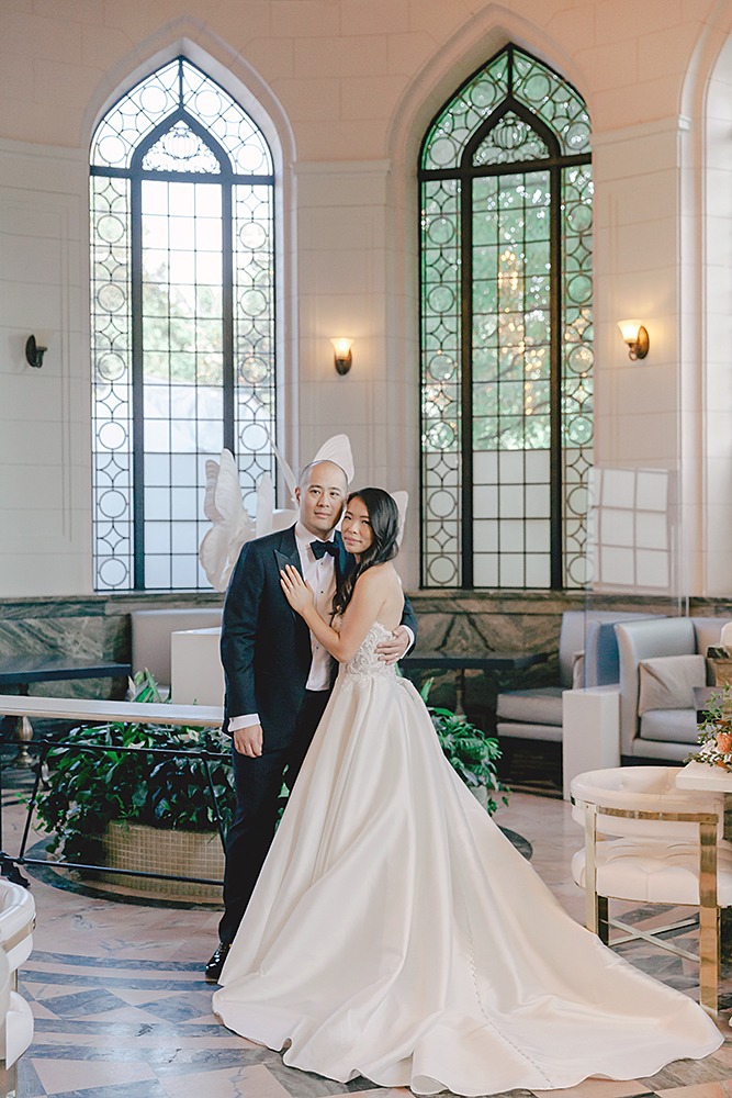 a formal portrait brides hand on grooms chest looking at the camera inside Casa loma