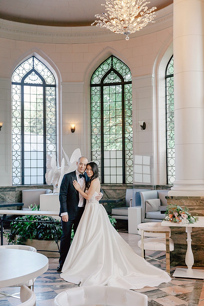 Photo of a wedding couple inside Casa Loma. HUgging couple