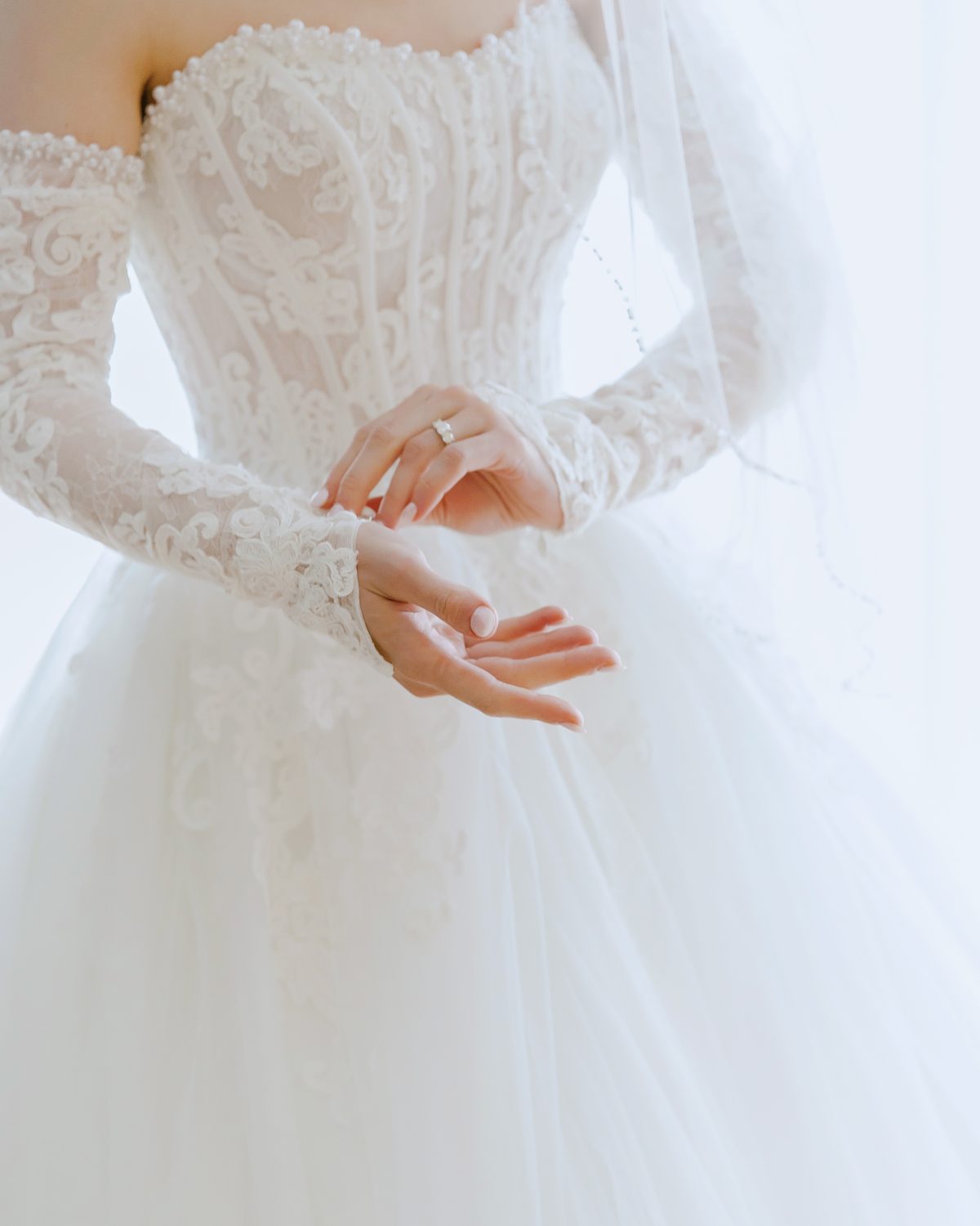 Bride is adjusting her lace sleeve of the dress Wakefield photographers Eva Hadhazy
