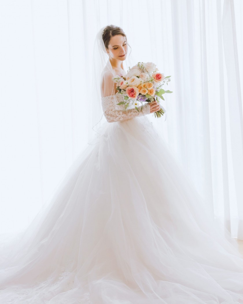 Bridal portrait at Wakefiled Mill, bride lookng at flowers