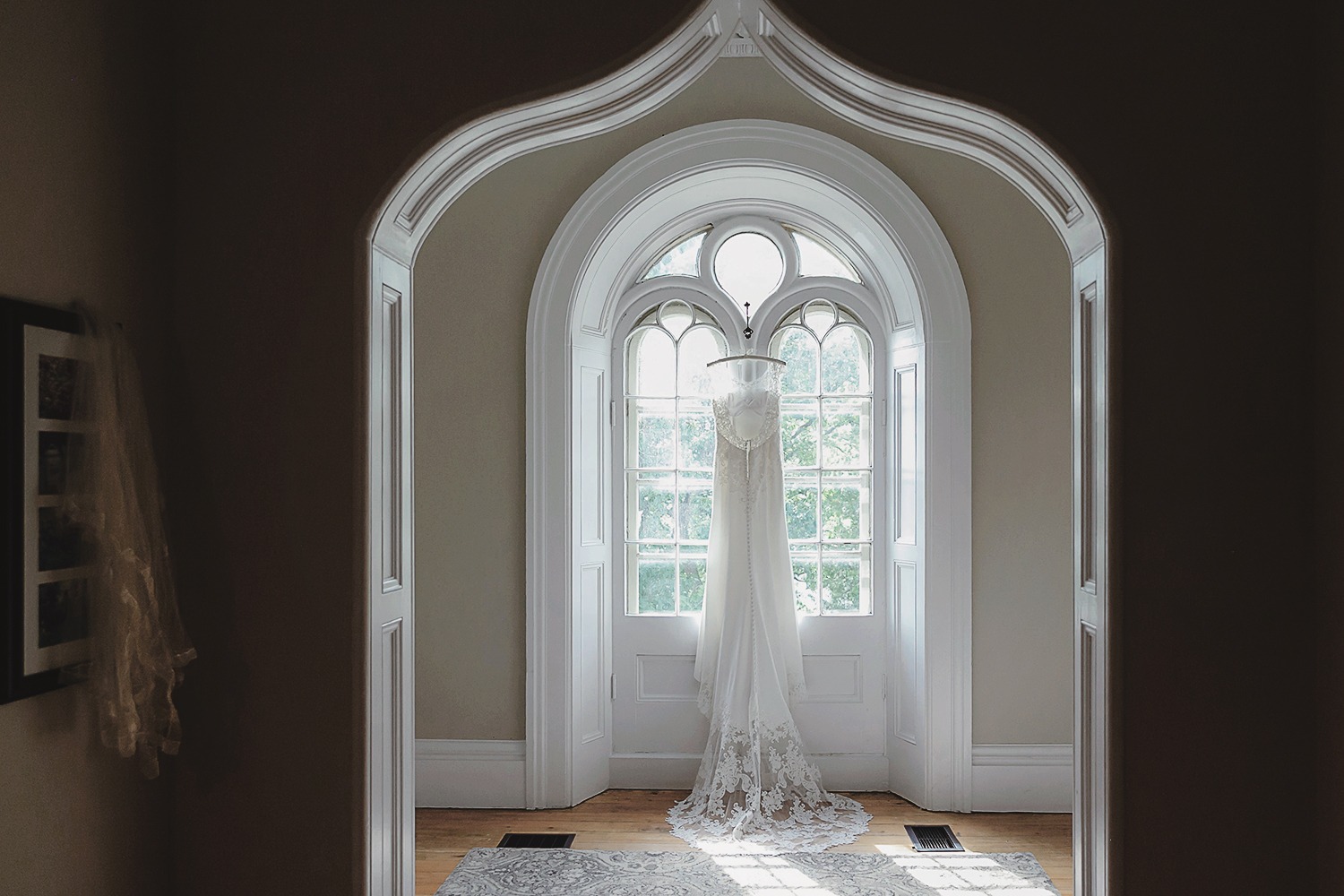 Wedding dress is hanging on the windows inside of the farmhouse at strathmere iconic wedding photo of the venue