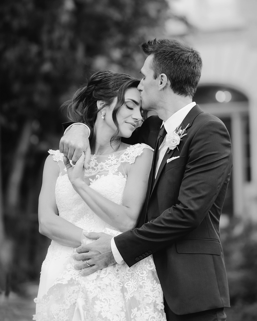 Black and white photo of bride and groom sharing an intimate, romantic moment