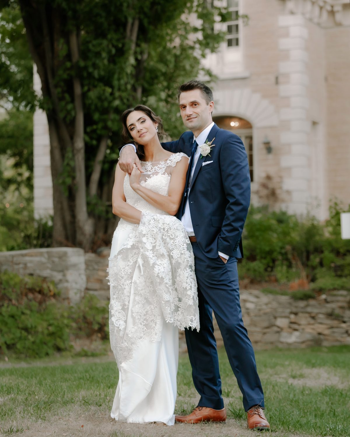 Bride and groom embracing, groom gently kissing the bride’s forehead, captured in a romantic moment