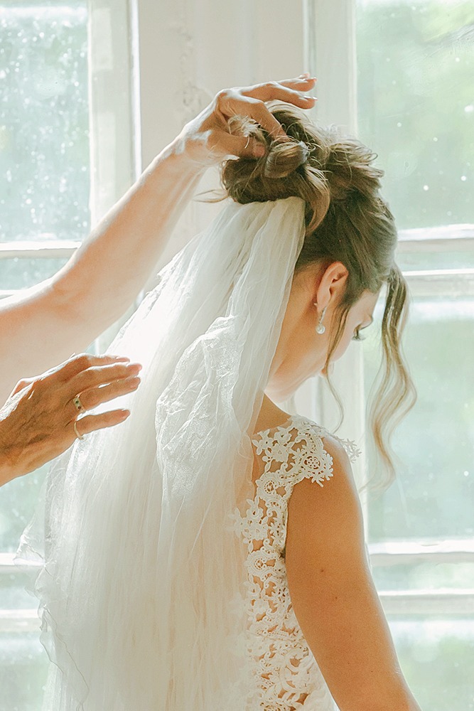 Mom is adjusting 4 generational veil on bride's hair
