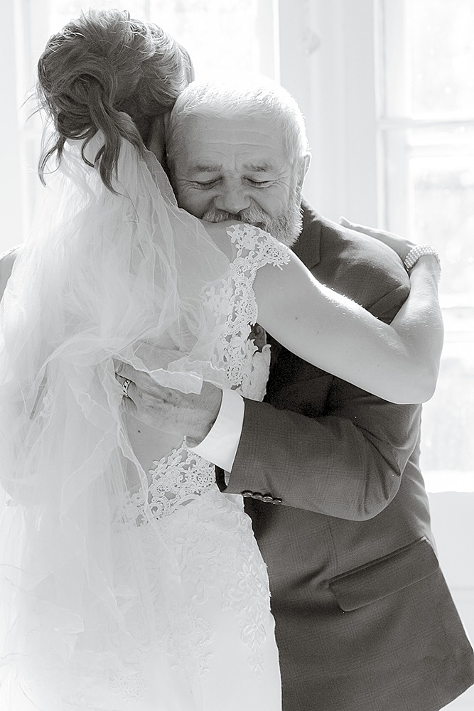 emotional hug between father and the bride