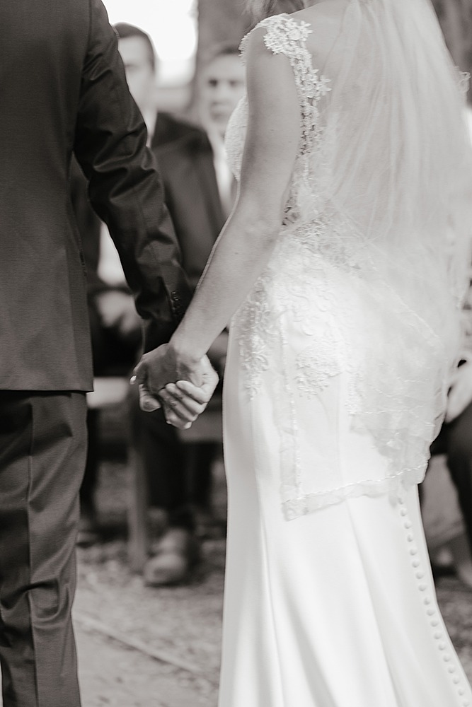 black and white image of couple's hands holding each other