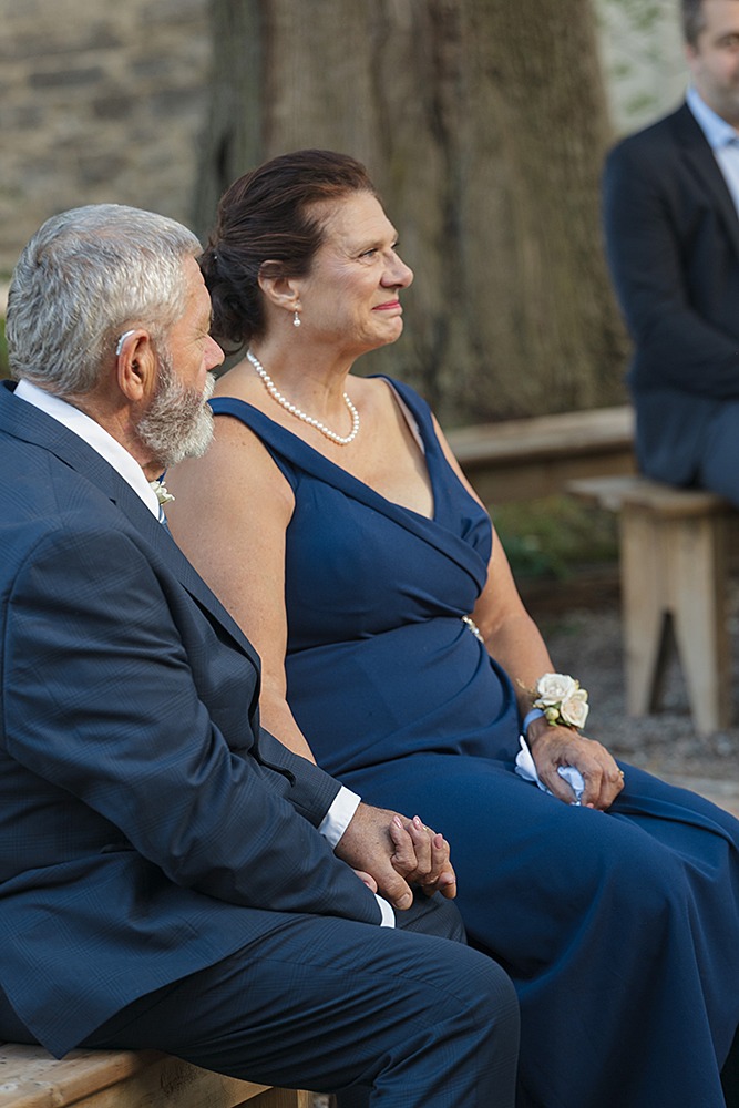 parents of Bride and groom holding hands, facing each other during the ceremony.