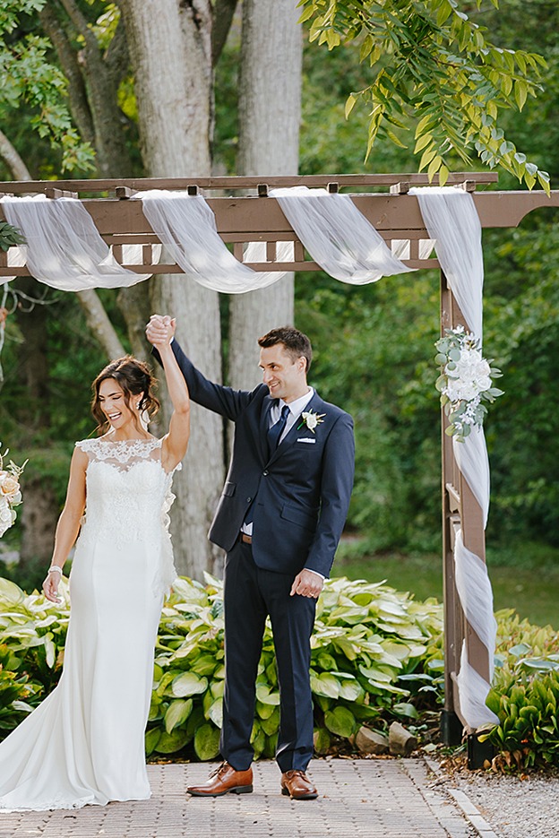 couple is cheering with their hands up in the air upon being announced and husband and wife