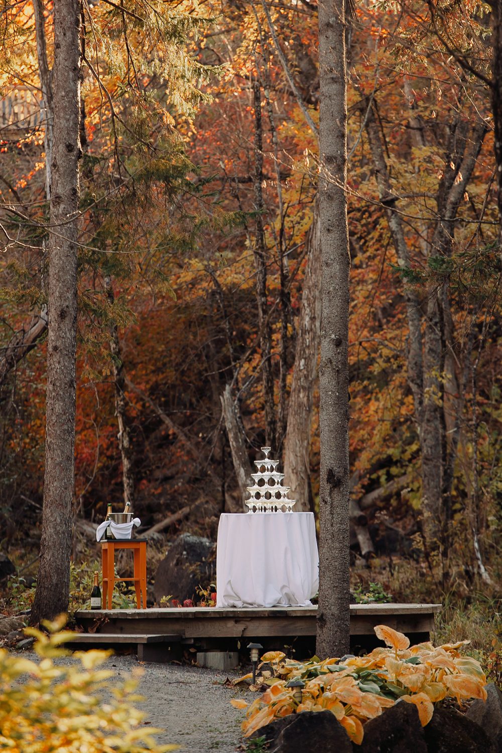 Champagne tower set up in the woods after ceremony