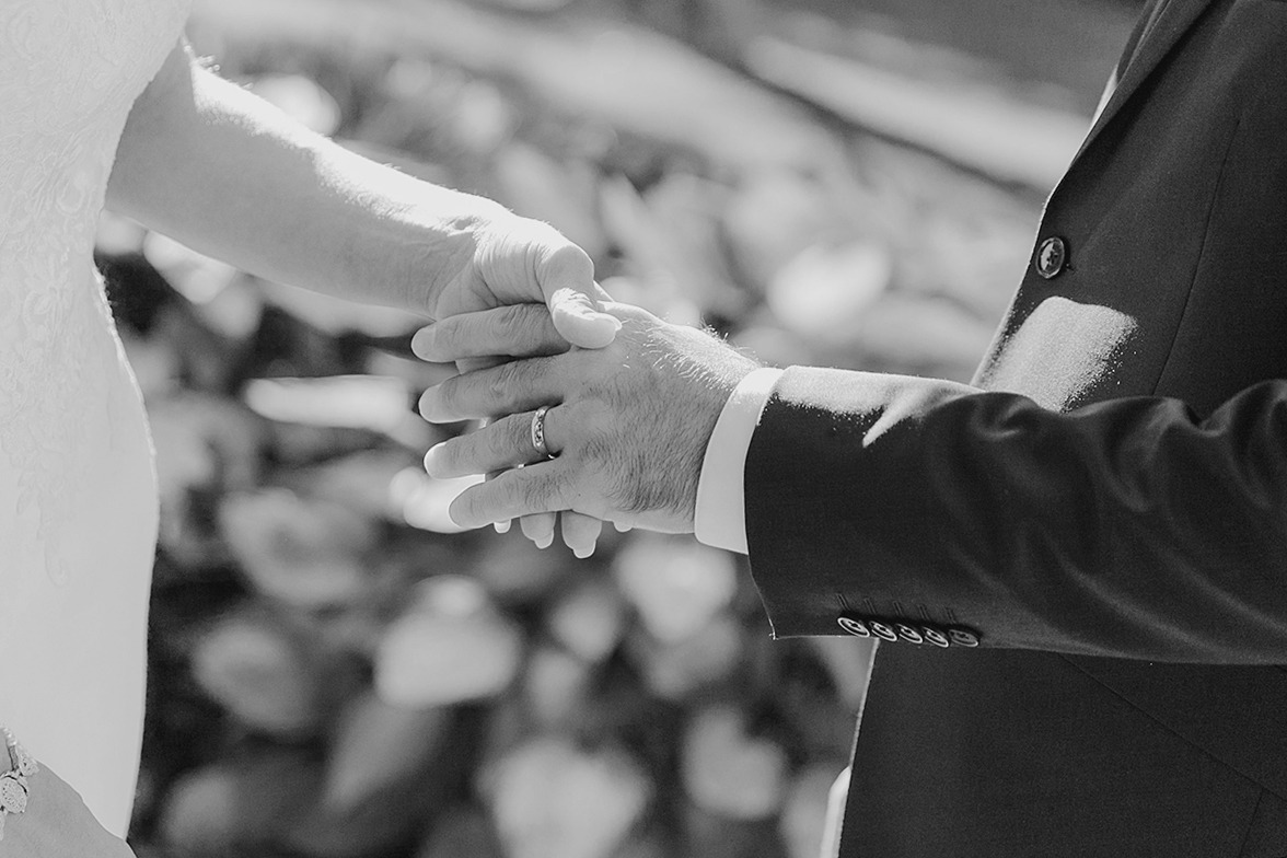 Hands of the couple during the ring exchange, highlighting the moment of commitment.
