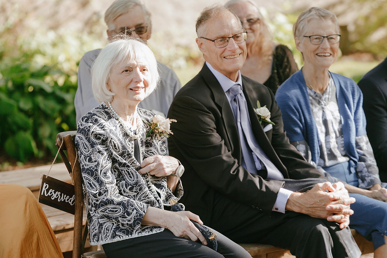 Parents of the bride and groom smiling warmly during the ceremony.