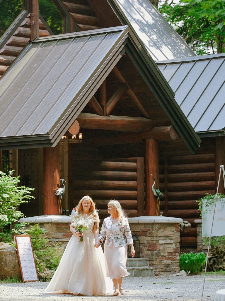 Bride and her mother walking down the aisle during an intimate cottage wedding ceremony in Calabogie, Ontario.
