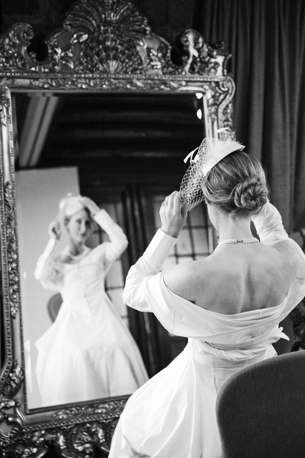 Montebello bride is adjusting her veil in front of a large mirror doumentary wedding photographer