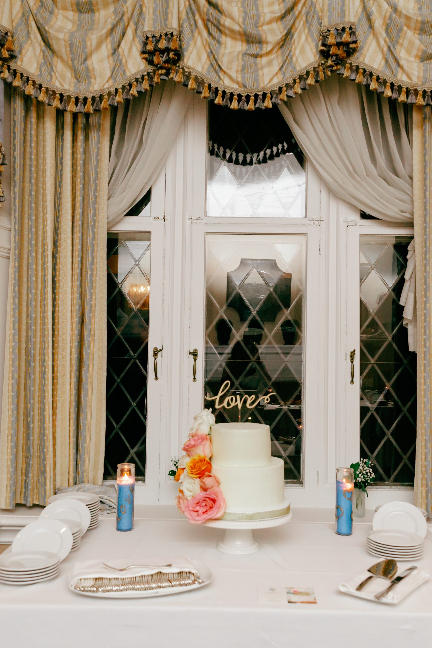 White wedding cake in window at Le Grodon Bleu wedding reception