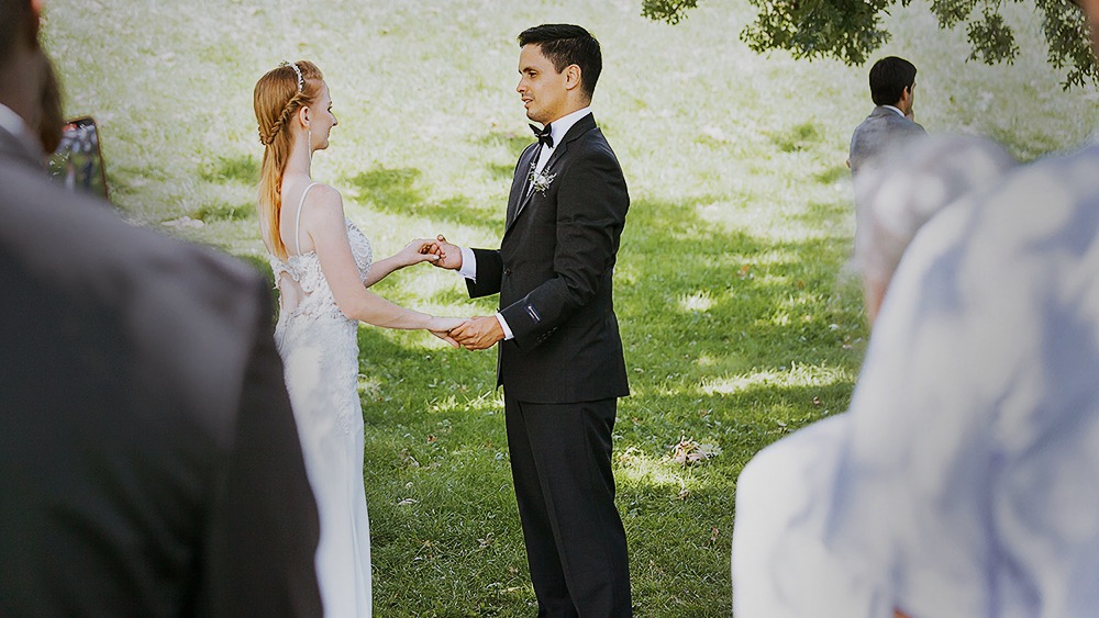 Couple standing under a maple tree at a small outdoor wedding in the Ottawa Arboretum.