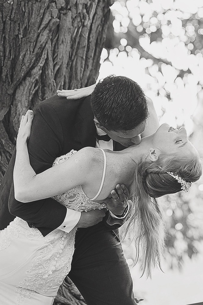 Bride and groom posing for portraits among trees in the Ottawa Arboretum
