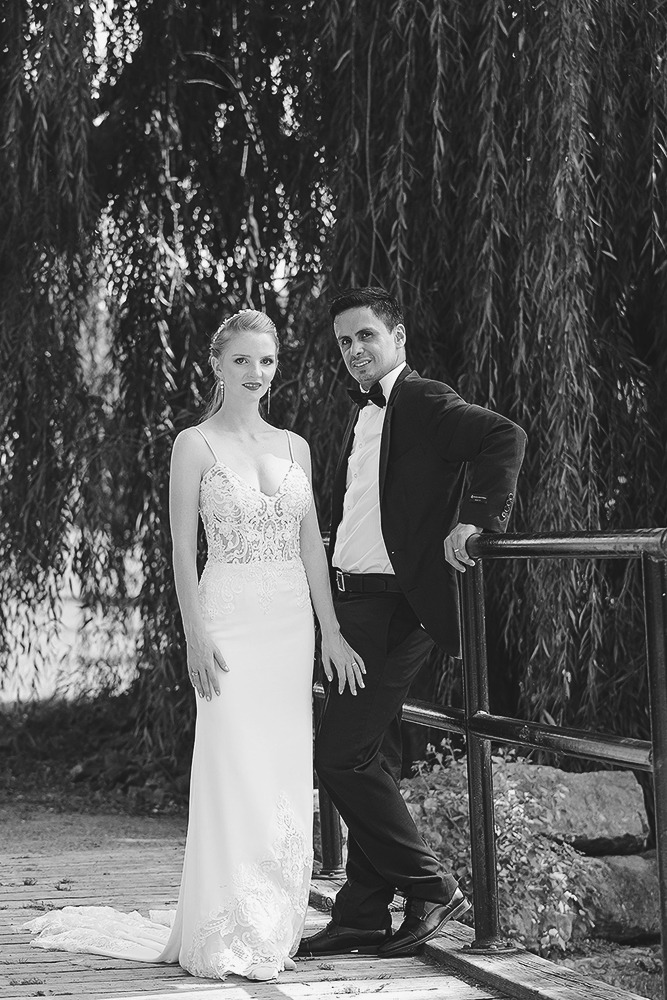 Bride and groom posing for portraits among trees in the Ottawa Arboretum